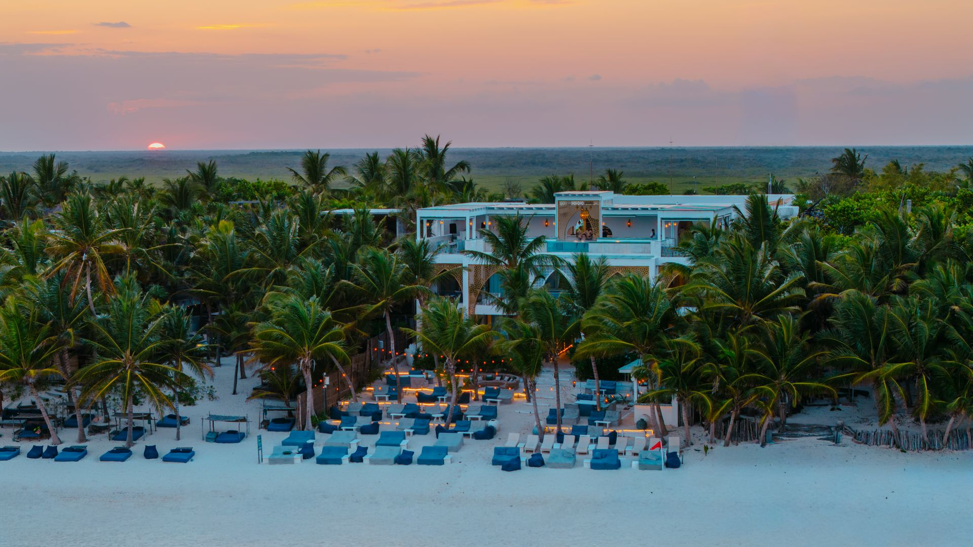Aerial view of the beachfront and sunbeds at sunset