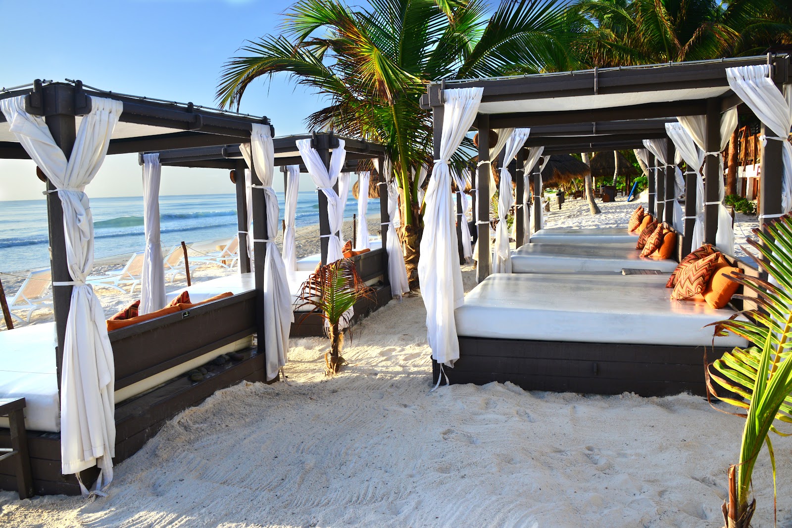 Curtained beach cabanas with daybeds at Ana y José Beach Club