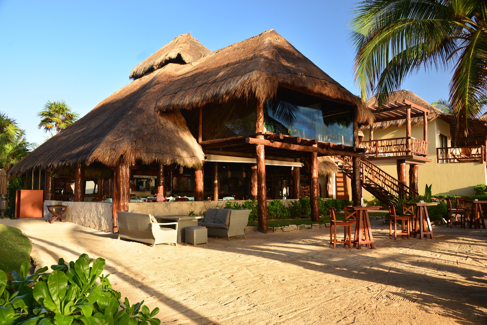 Thatched-roof main building on the sand at Ana y José Beach Club