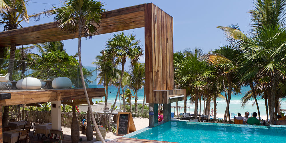 Pool and palms overlooking the Caribbean at Be Tulum
