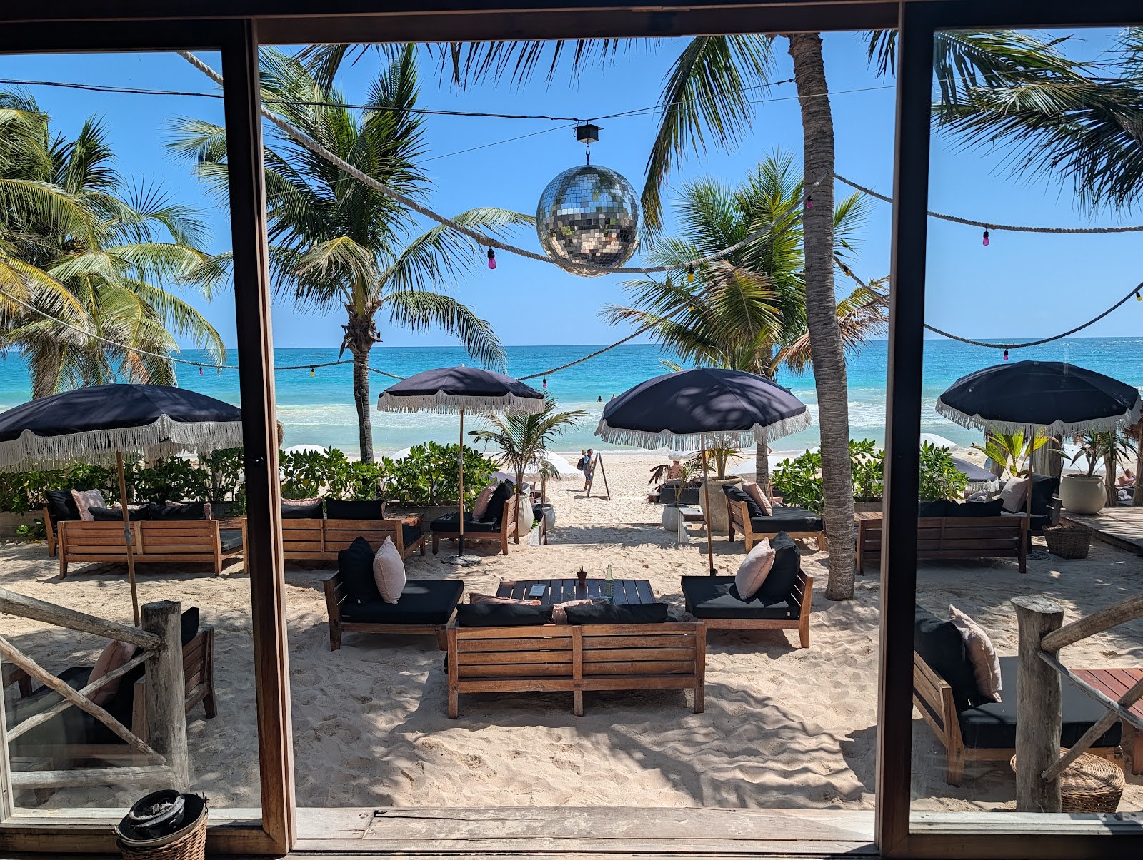 Beach lounge area with a hanging swing and palms