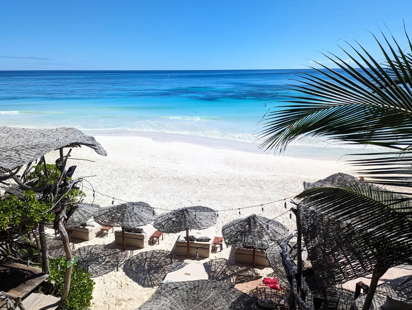 Beach loungers on white sand with turquoise water