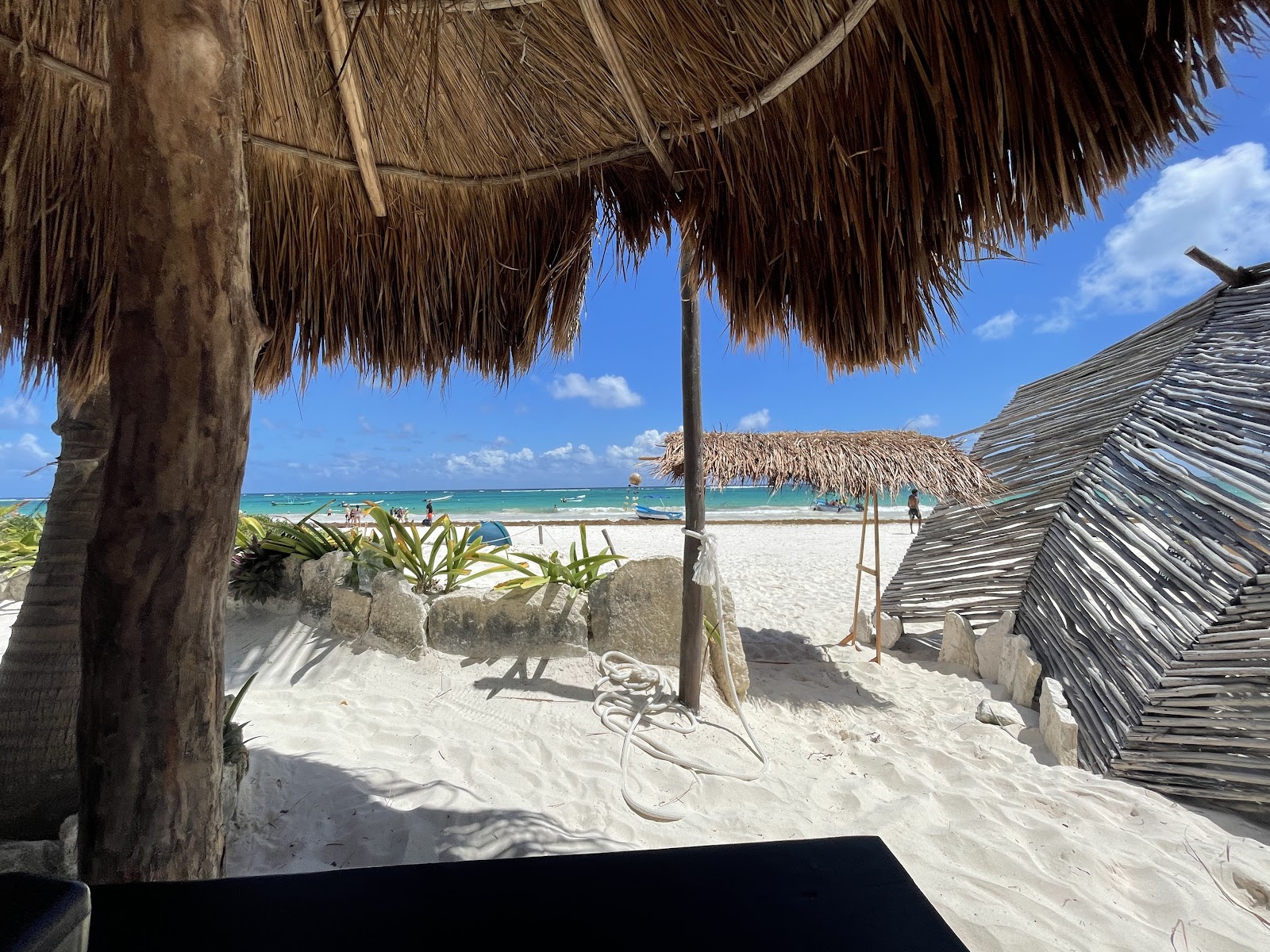 Beach view framed by a palapa roof