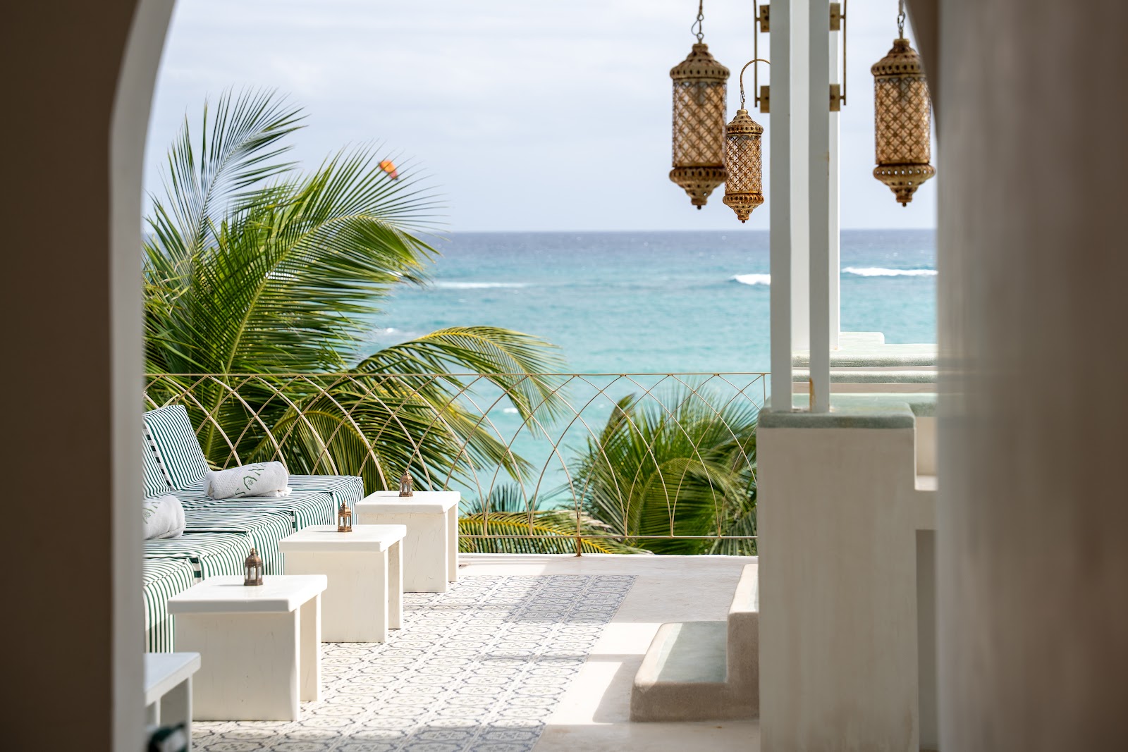Beachfront terrace with white loungers overlooking the sea