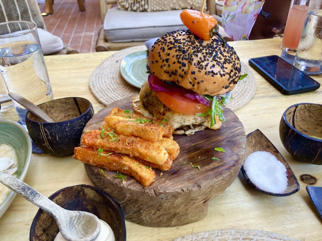 Burger with fries and sides served on a wooden board
