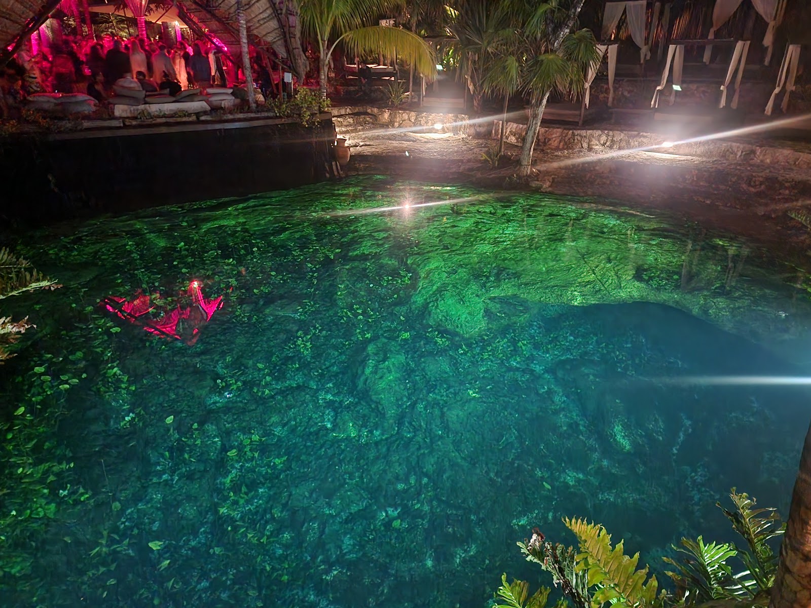 Cenote water glowing under lights at night