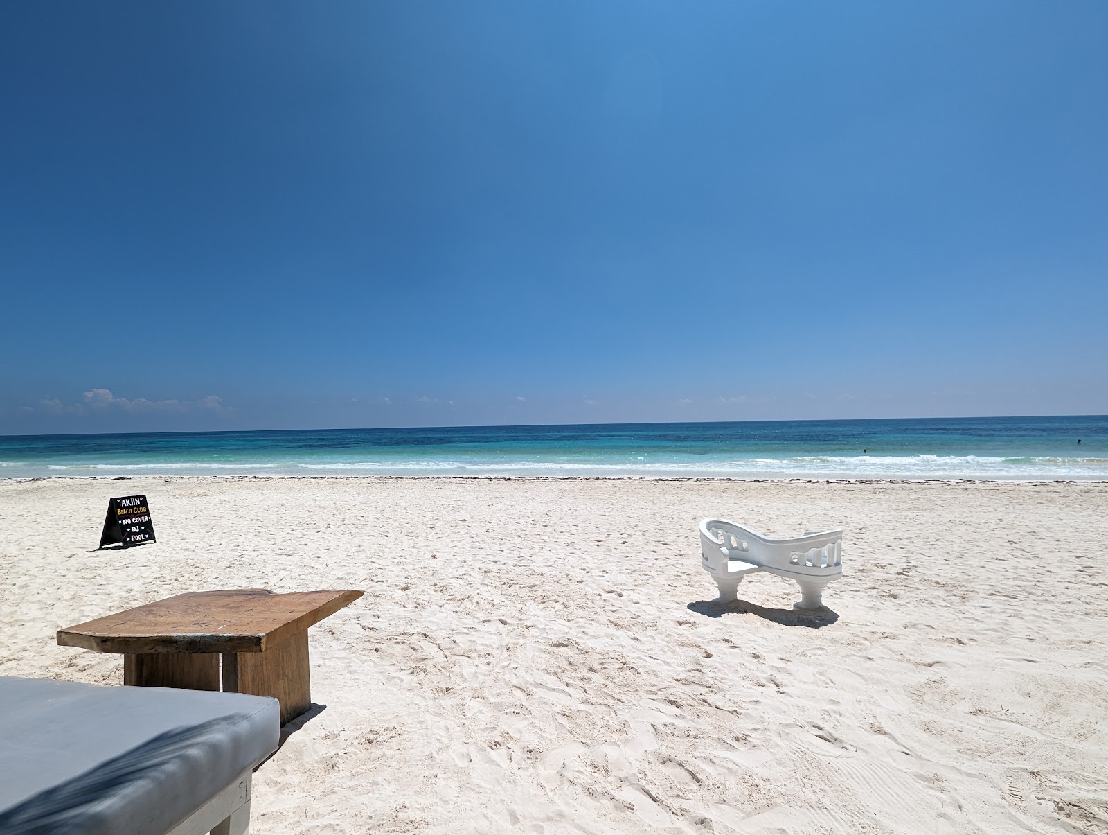 Clean white sand beach with a lounge table