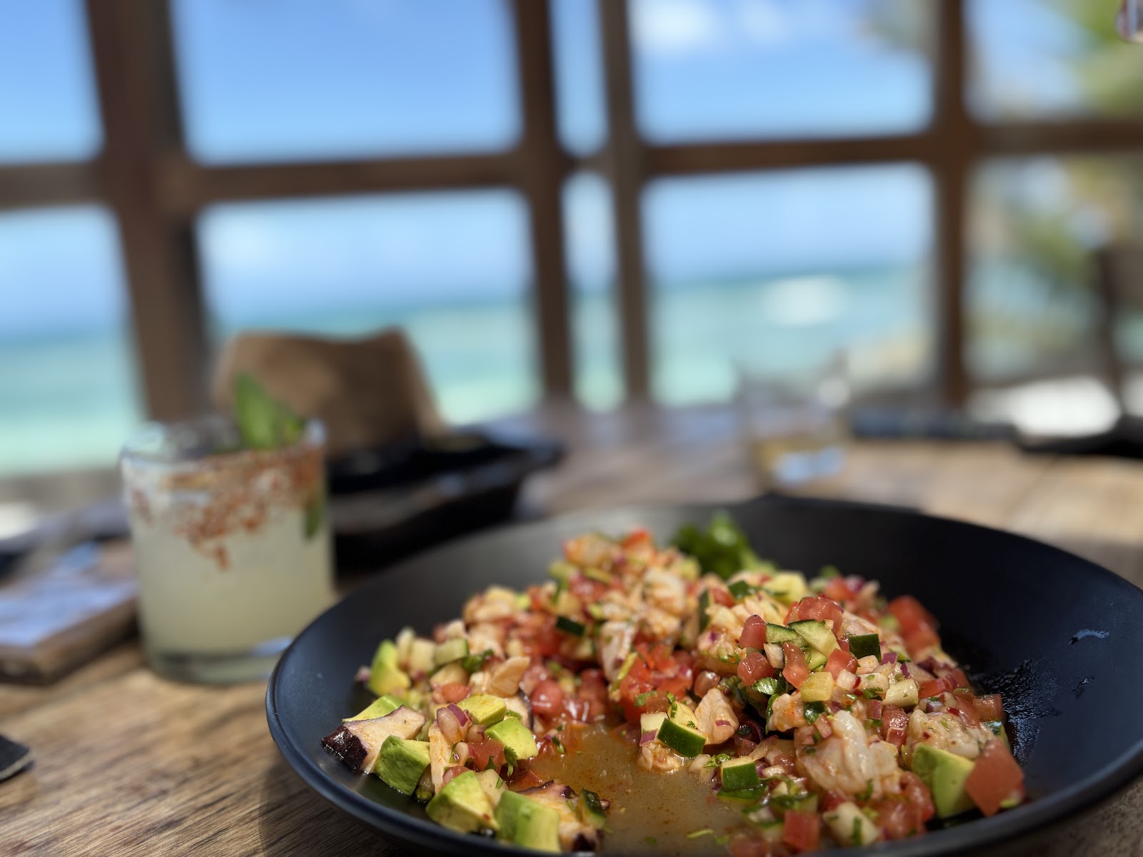 Cocktail and fresh ceviche with a sea view