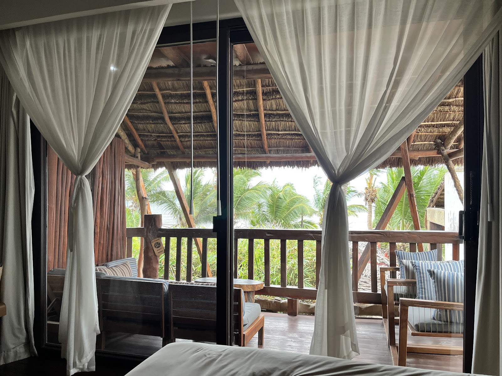 Daybed framed by white curtains