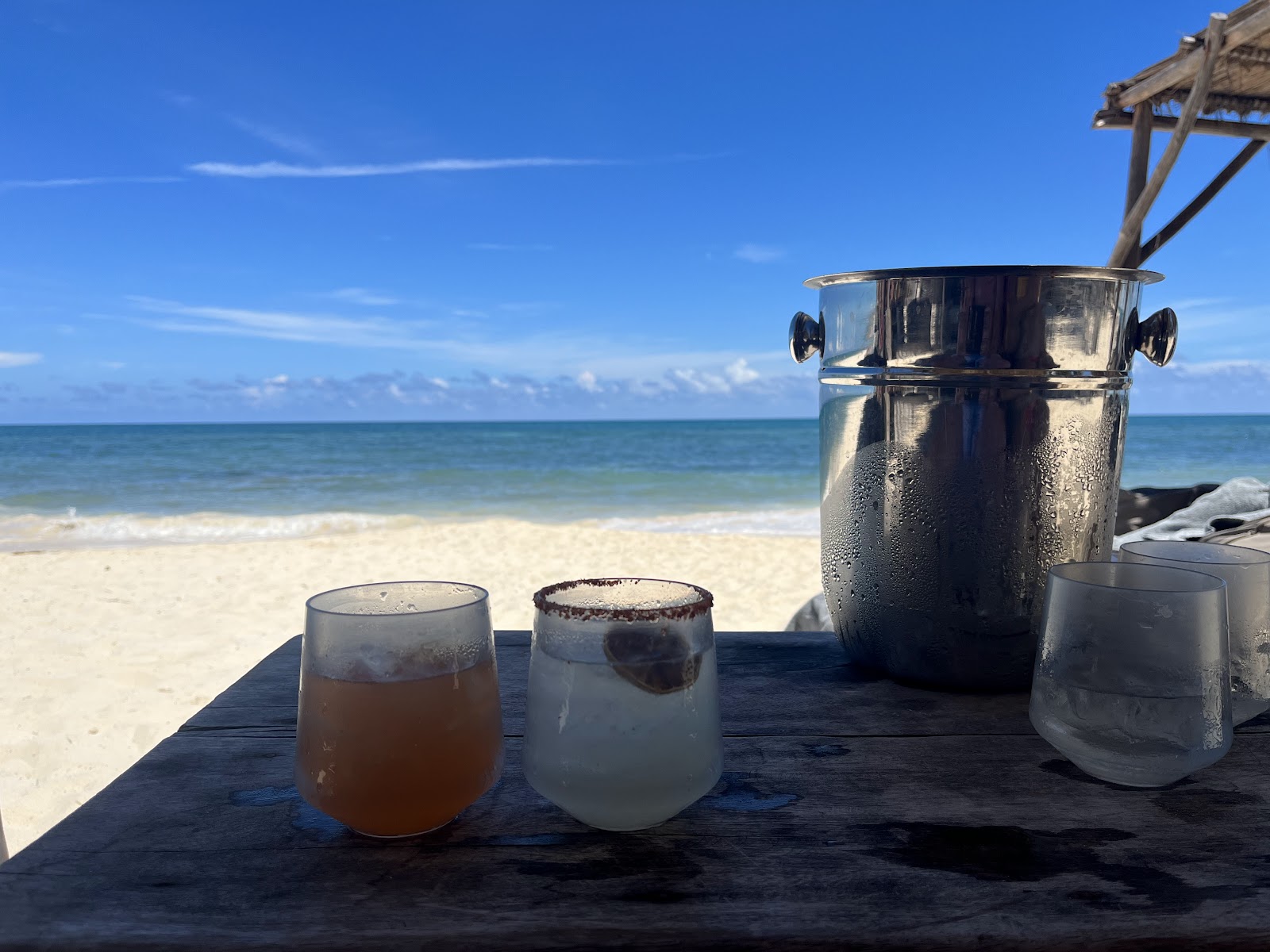 Drinks and ice bucket served on a beachfront table
