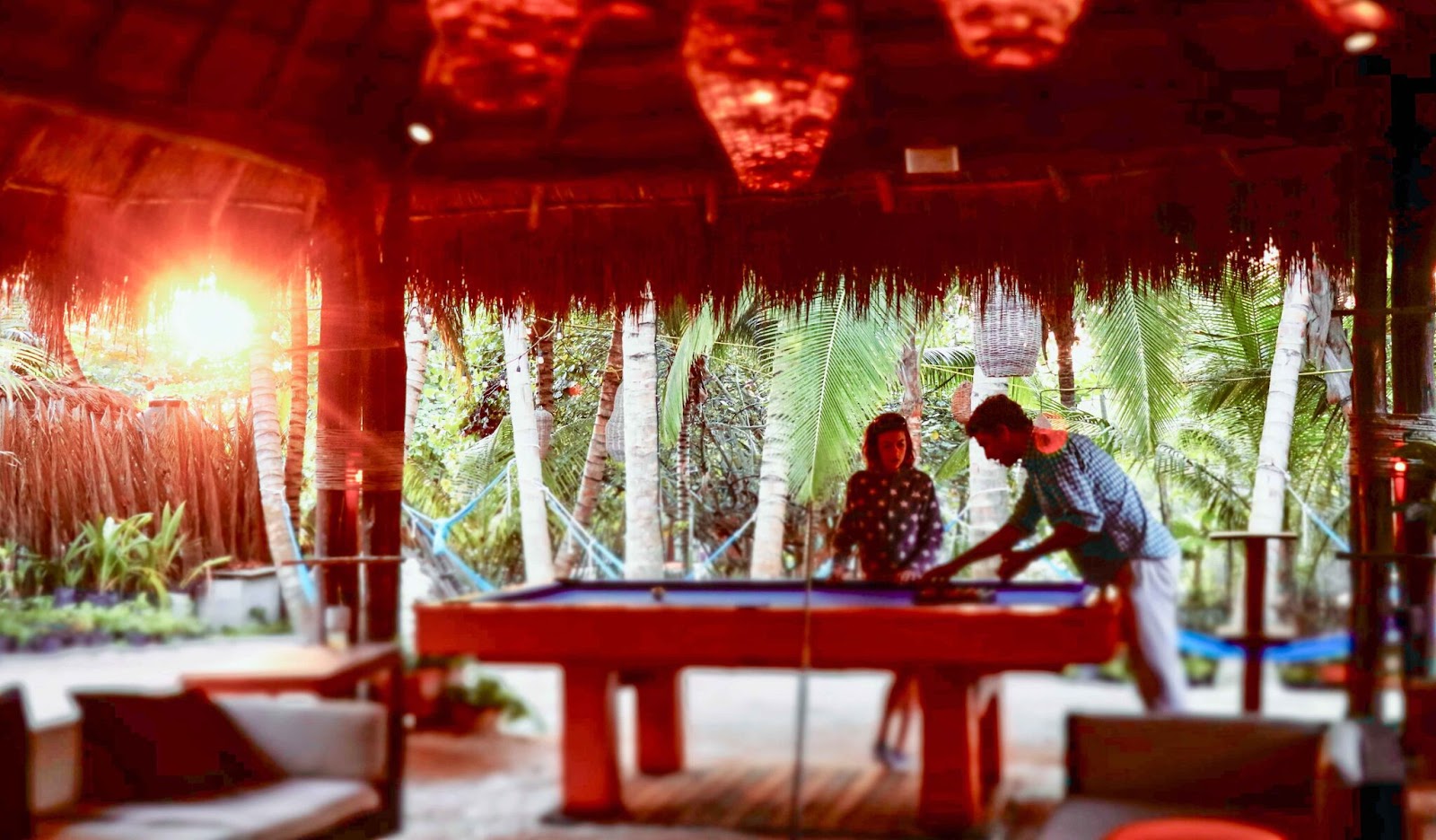 Games area with a pool table under a red palapa
