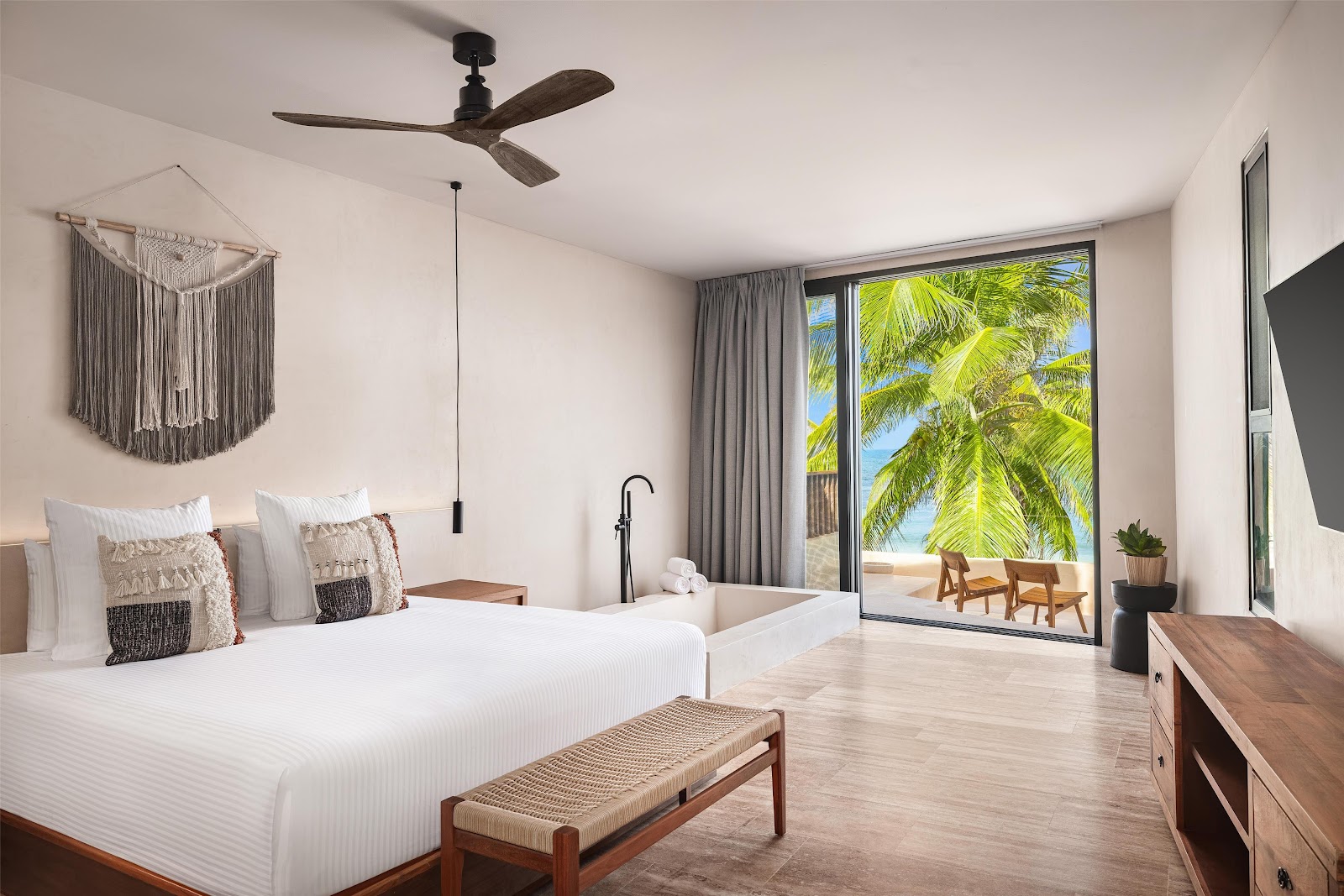 Guest room with large windows and tropical views