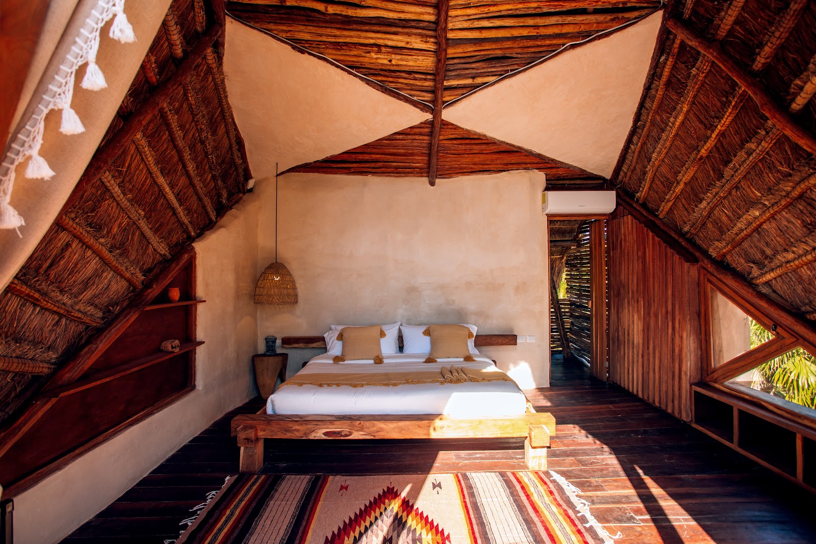 IKAL Tulum room with a pitched wooden ceiling