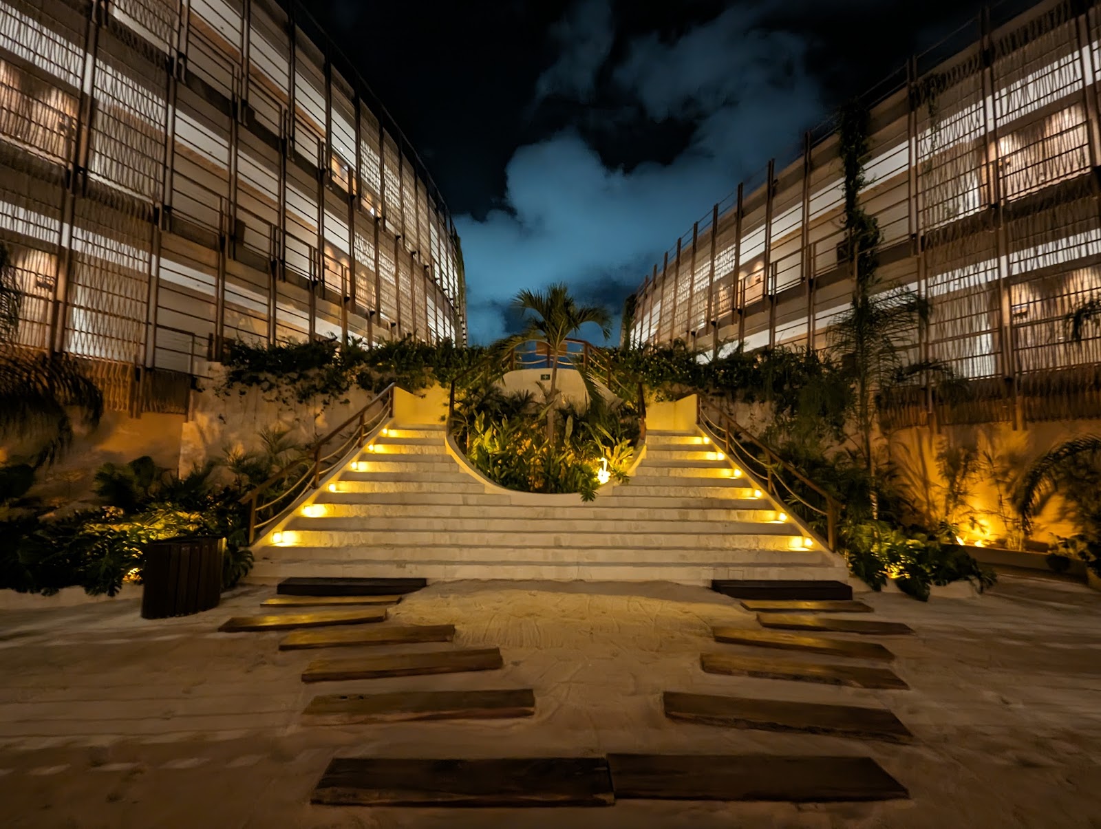 Illuminated pathway between resort buildings at night