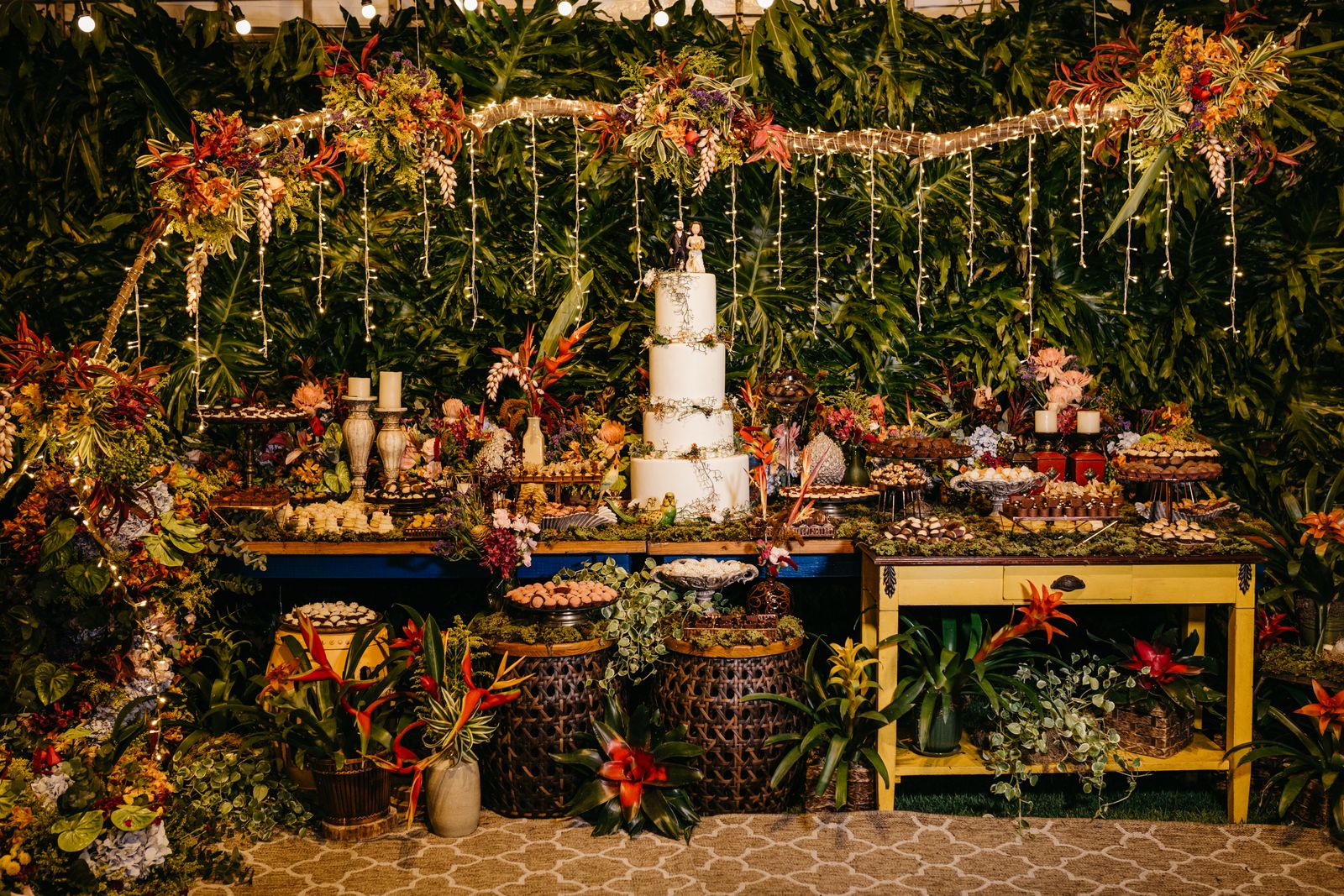 Wedding cake and dessert table decorated in a jungle setting