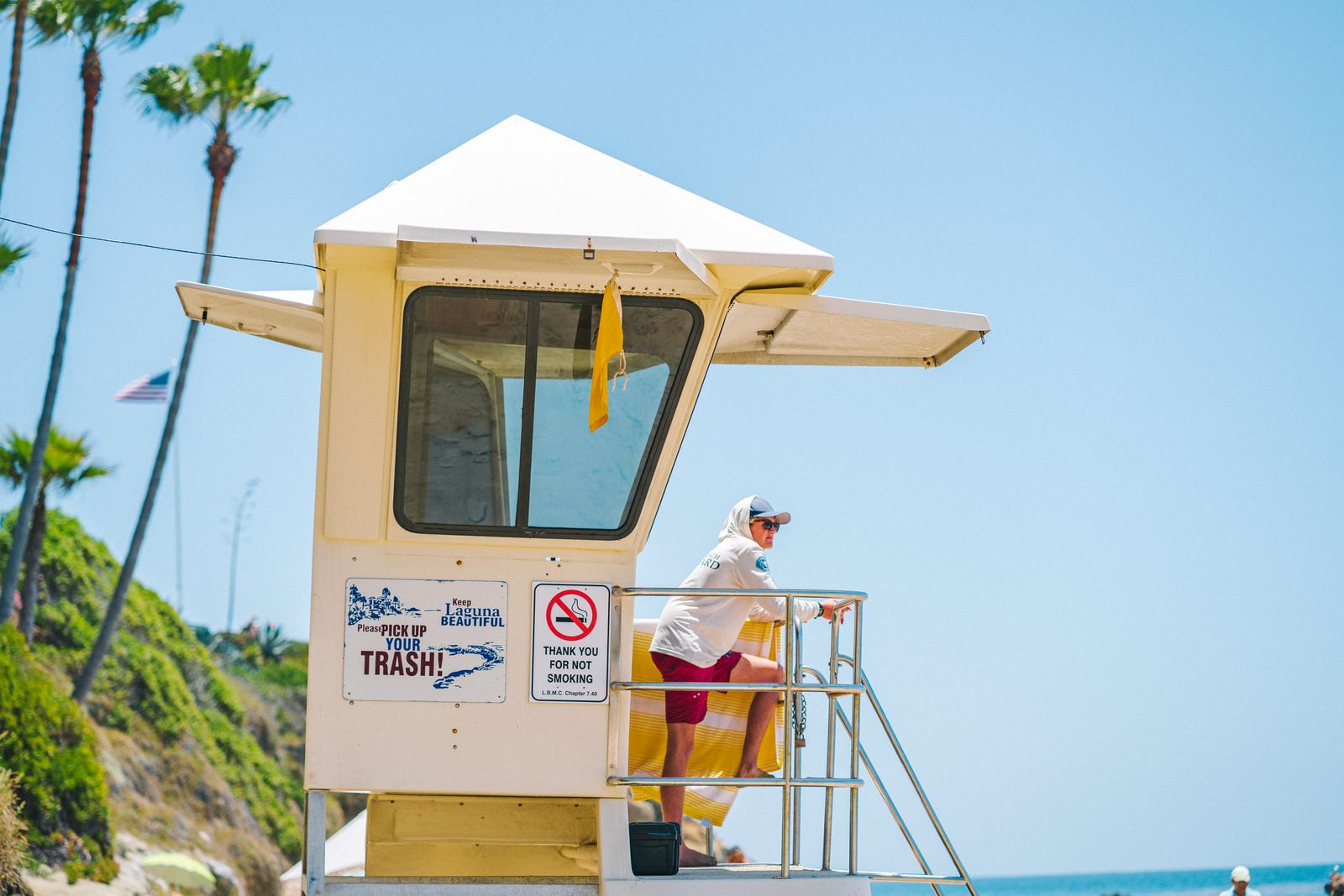 Lifeguard standing on a lifeguard tower on the beach