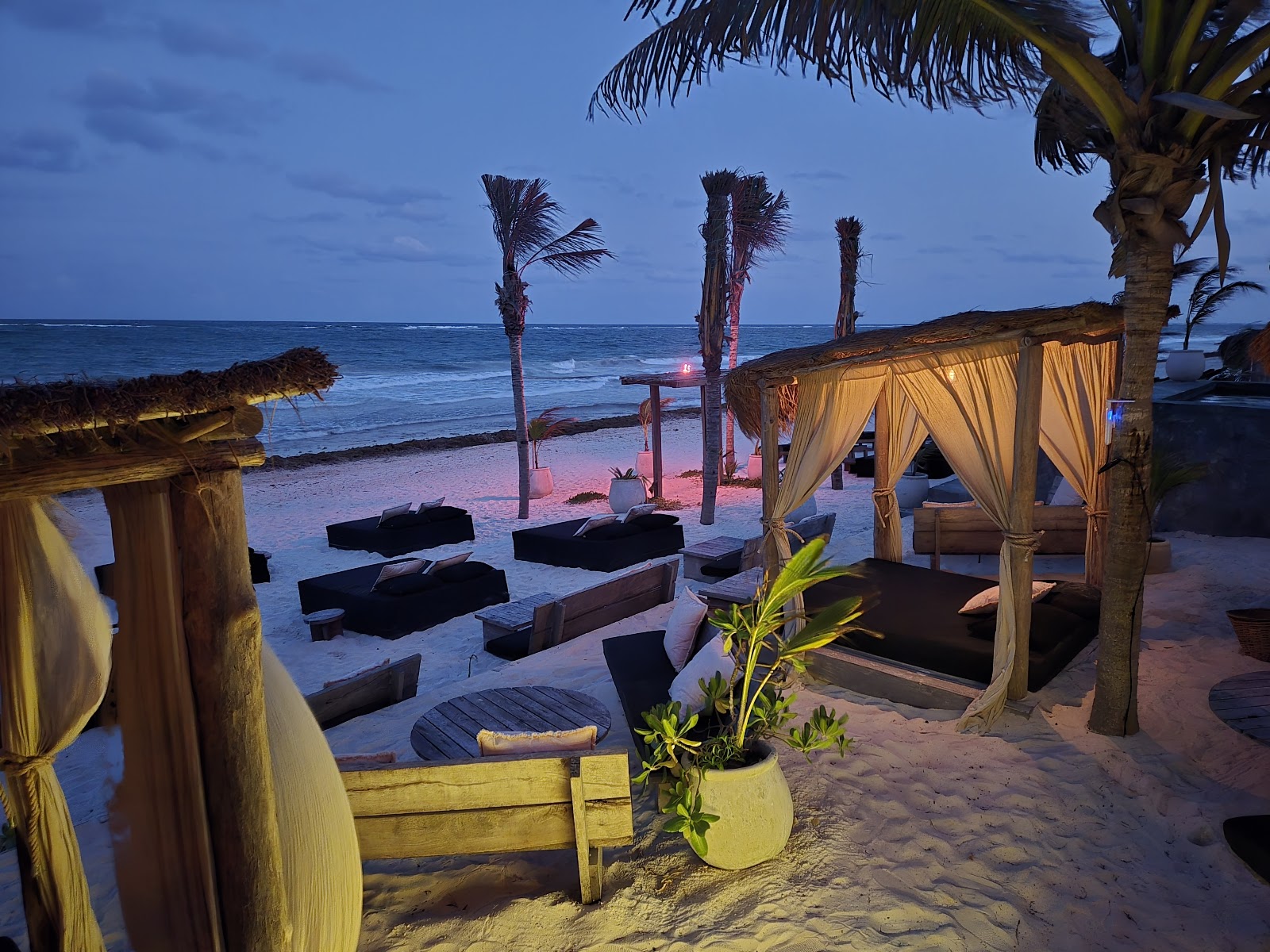 Lounge area with daybeds by the sea at dusk