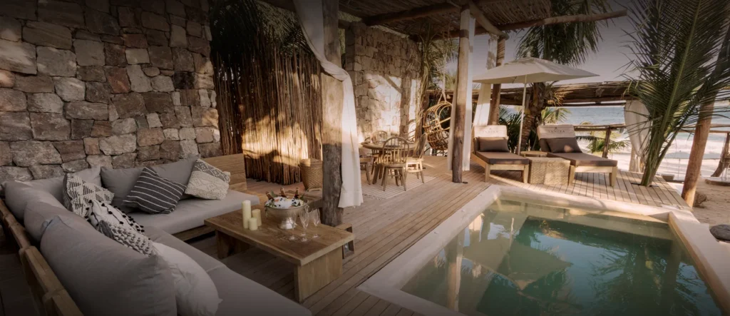 Stone walled lounge with sofas beside a private plunge pool