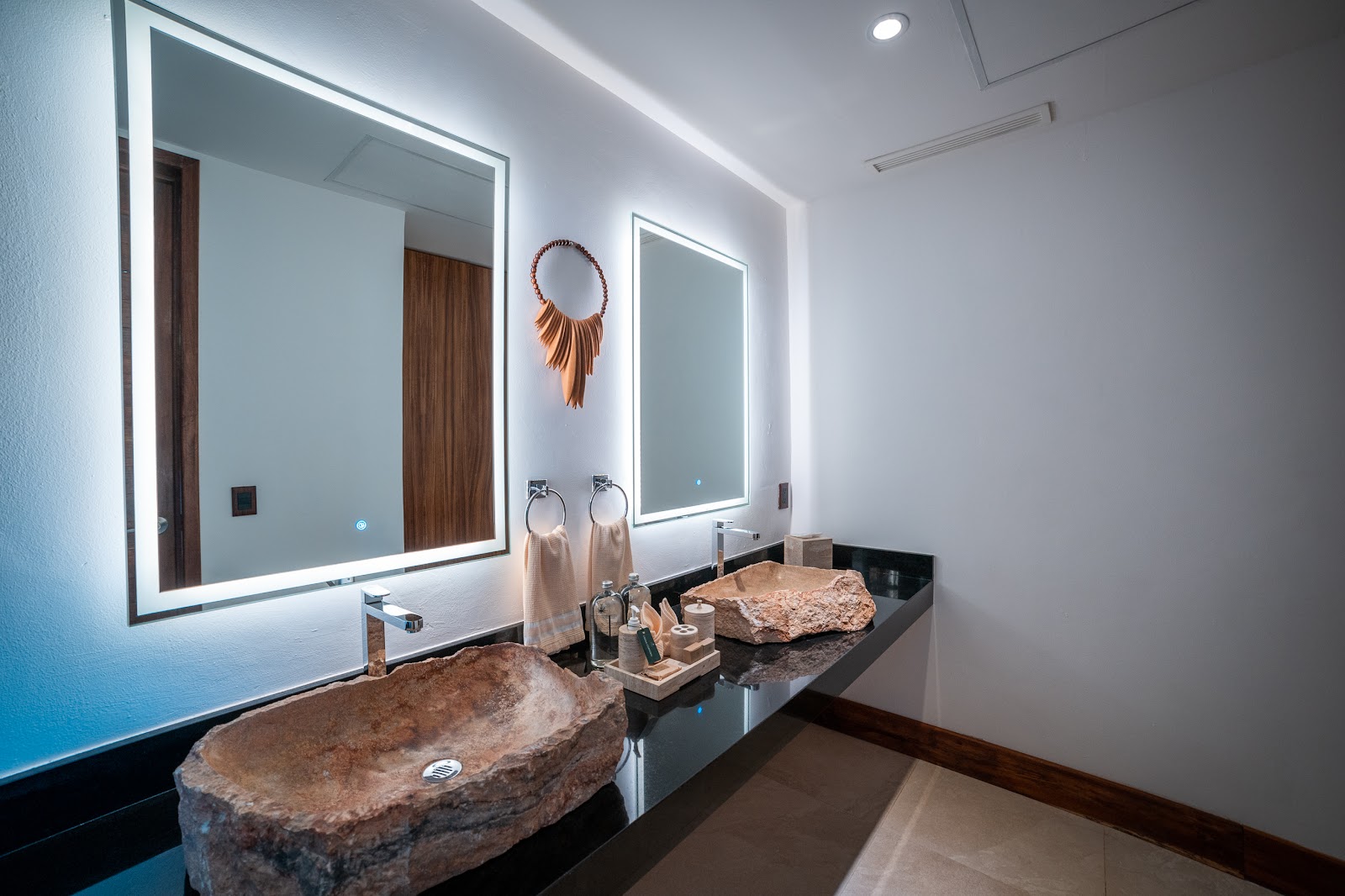 Modern bathroom with stone vessel sink and illuminated mirrors