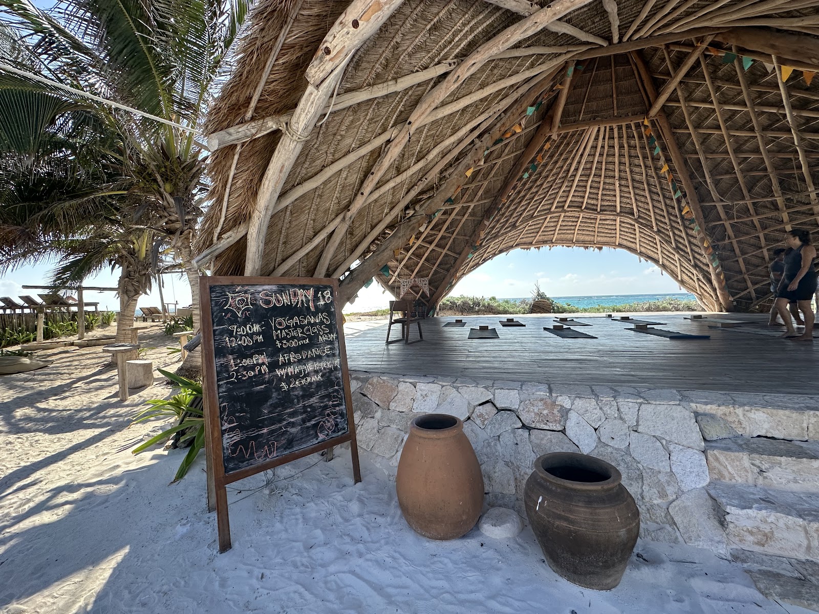 Open-air palapa on the beach with rustic pots