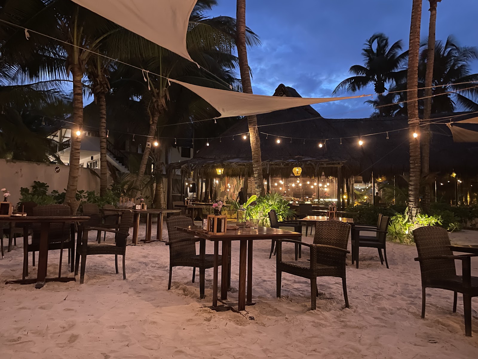 Neatly arranged outdoor tables under shade sails