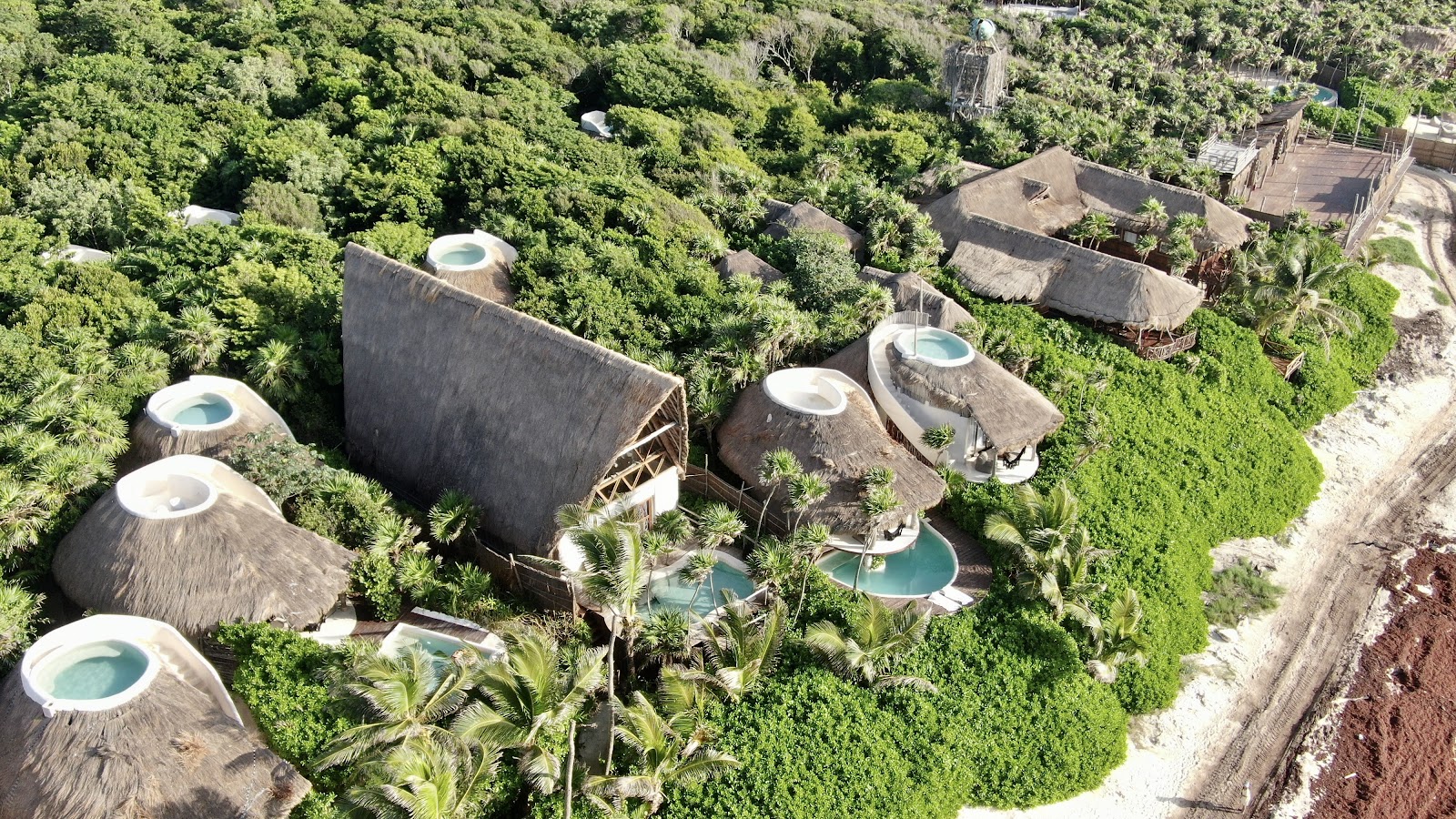 Papaya Playa Project cabanas nestled in the jungle from above