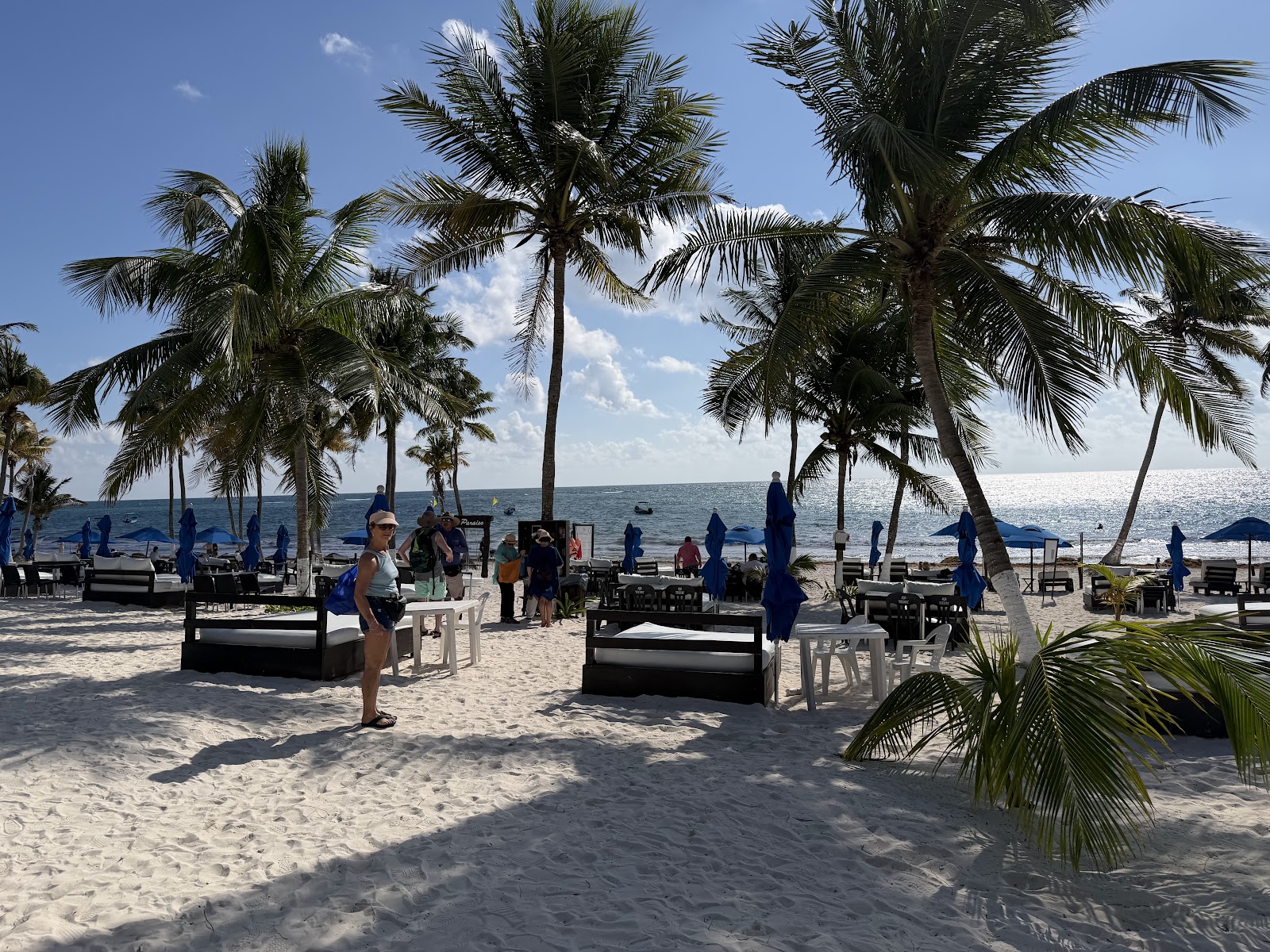 Playa Paraíso Beach Club tables and umbrellas under the palms