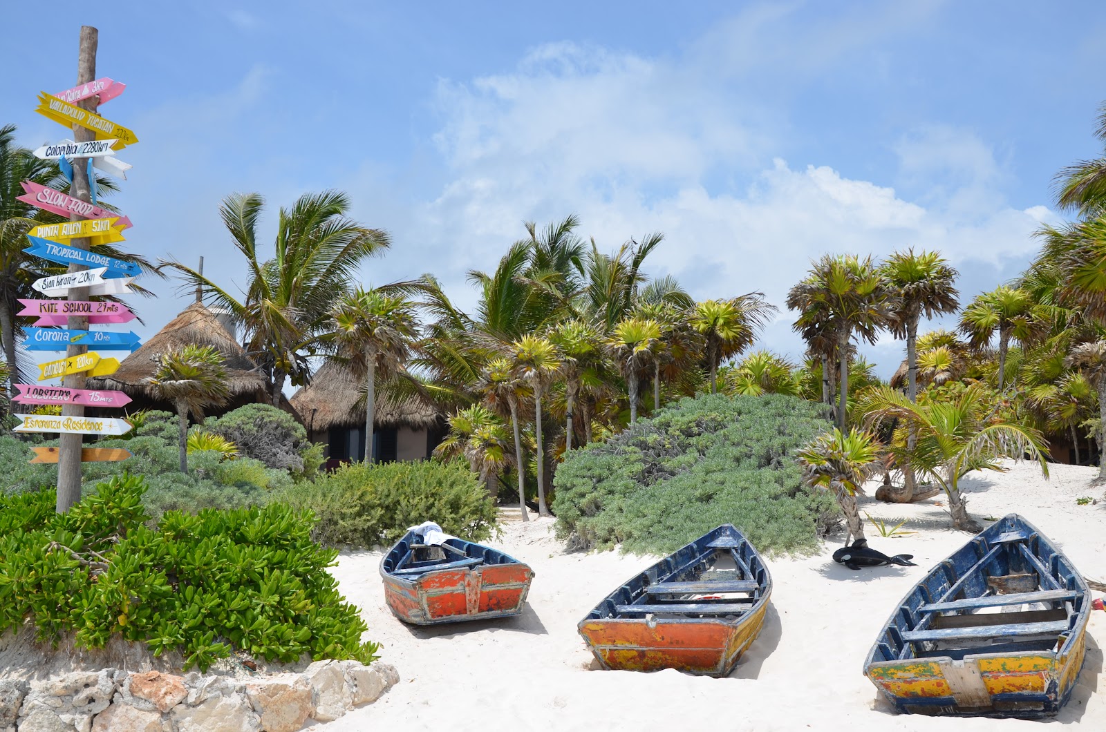 Colorful painted boats and signposts at Playa Paraíso