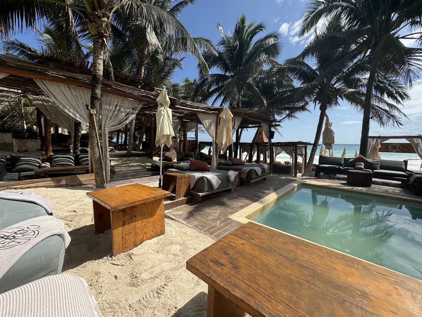 Swimming pool surrounded by cabanas and palm trees