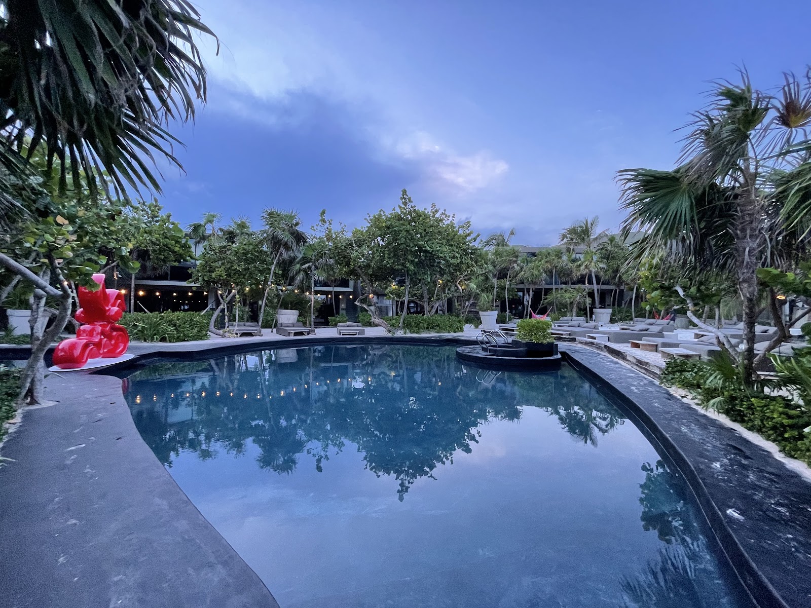 Pool reflecting the sky and palm trees