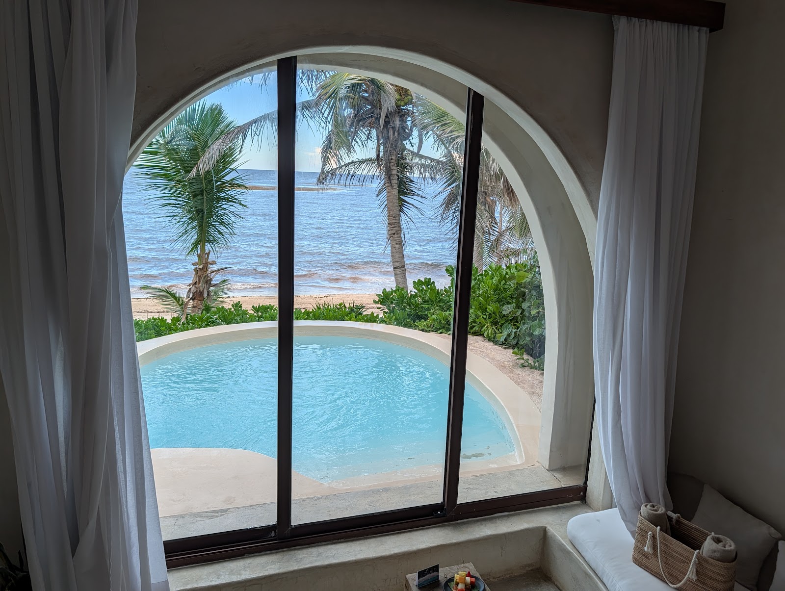 Private pool seen through the arched windows of a villa