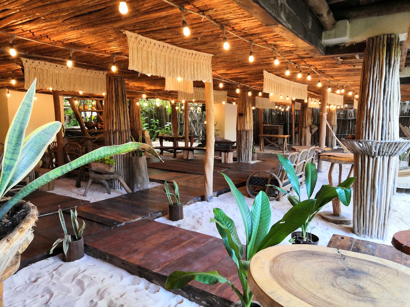 Restaurant with wooden tables and tropical plants