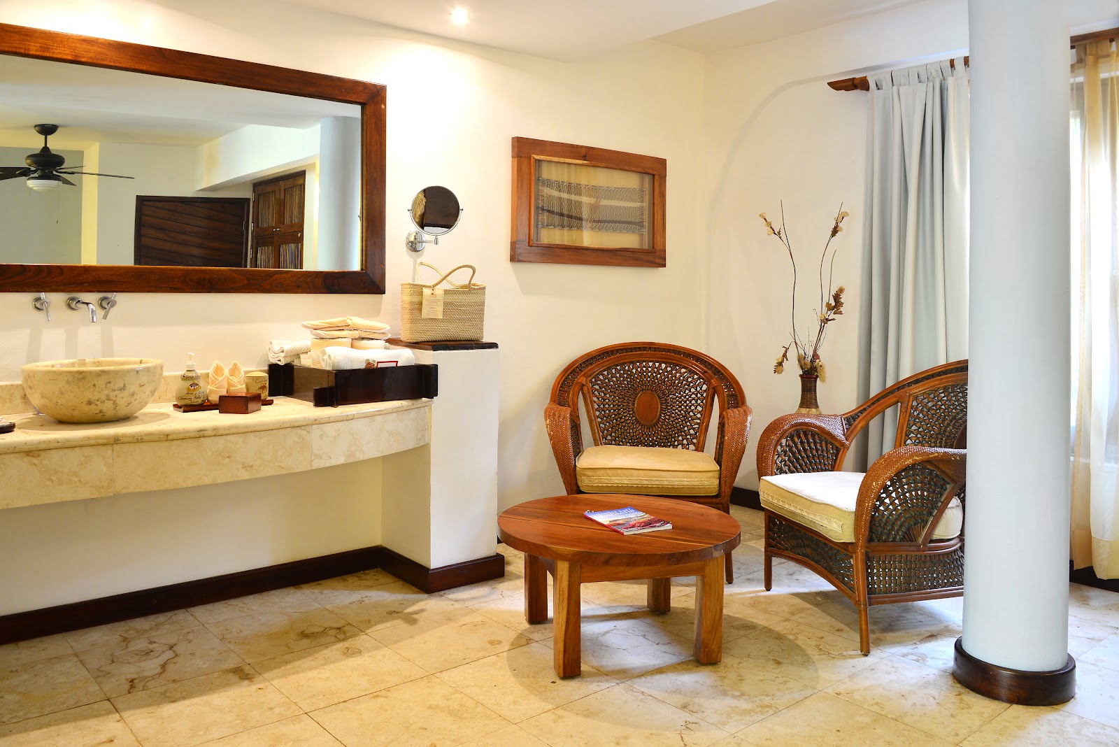 Room with vanity area and wicker armchairs