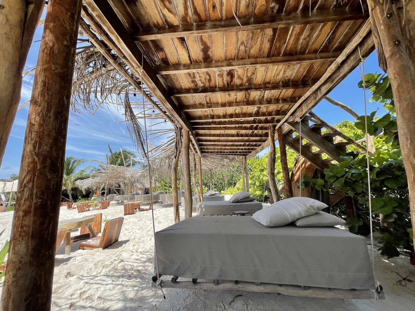 Shaded daybeds under a wooden pergola