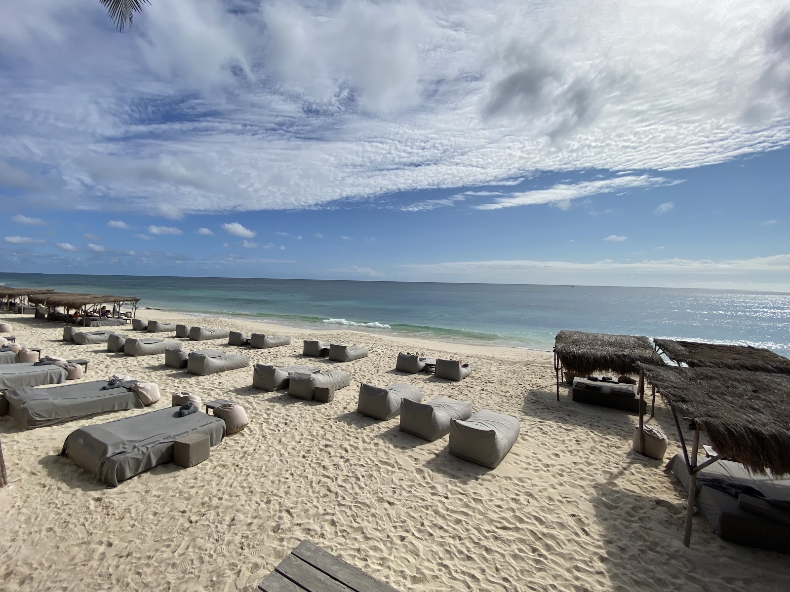Sun loungers lined up on a wide white sand beach