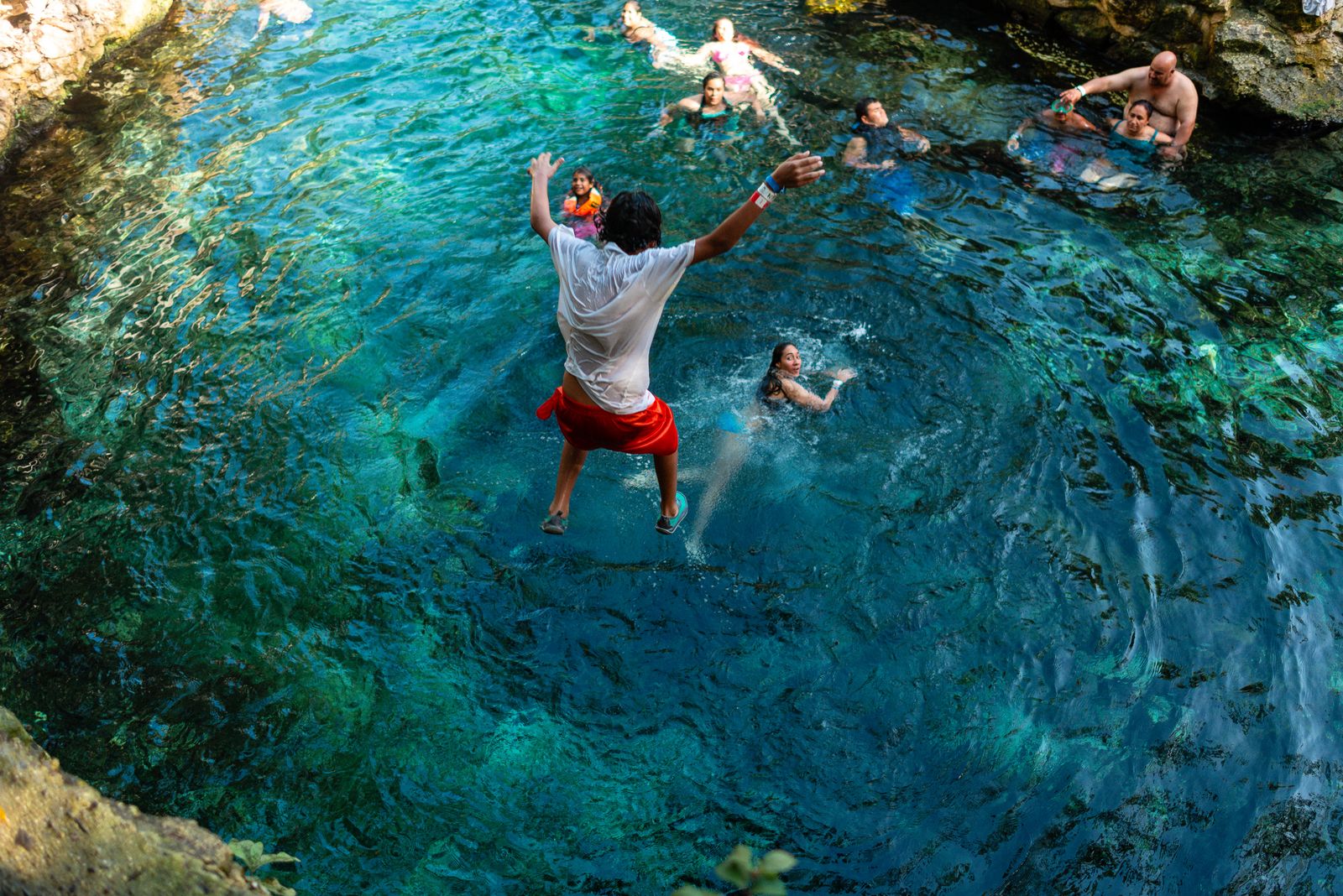 Swimmer in the clear turquoise water of a cenote
