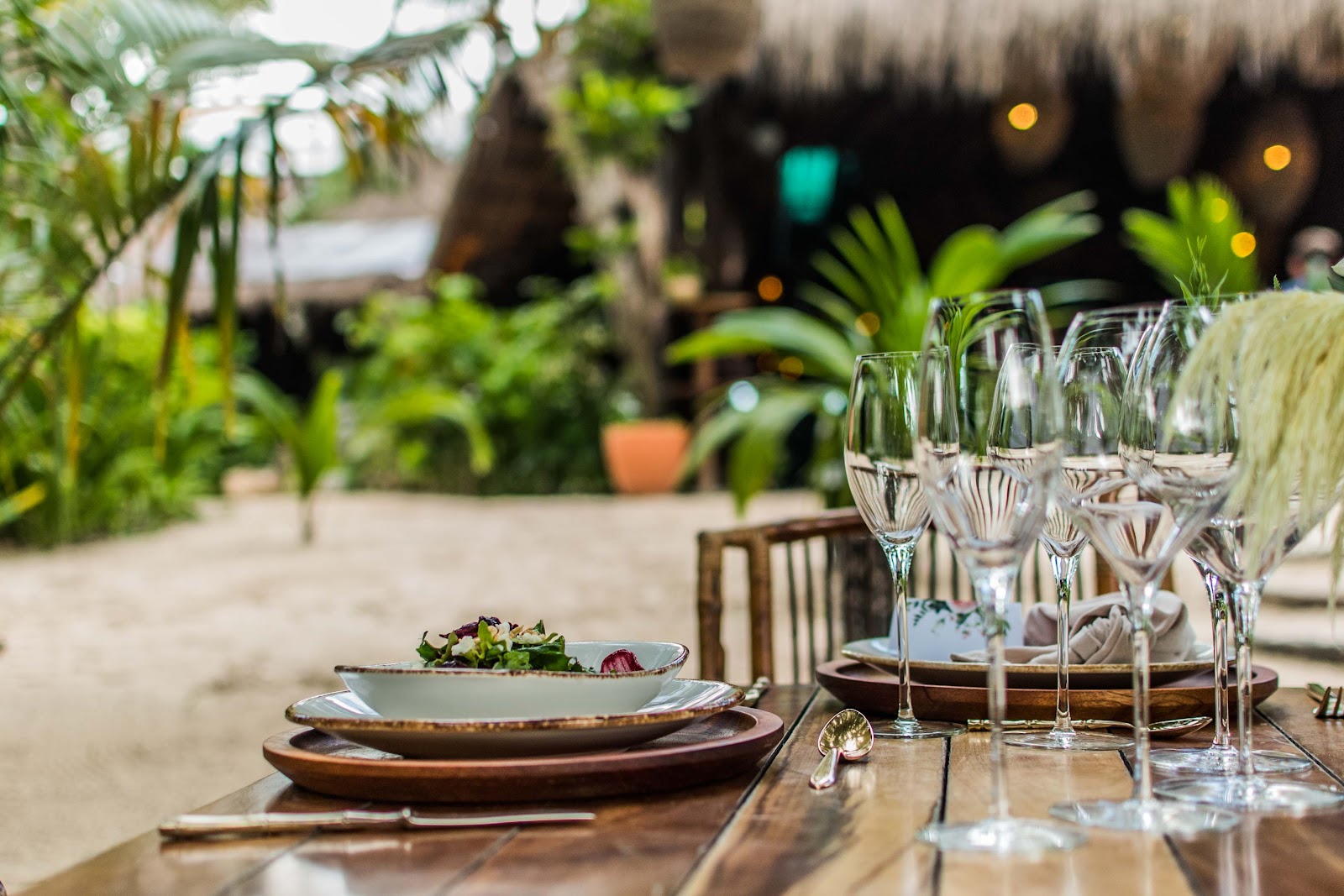 Table set with glassware under the palm trees