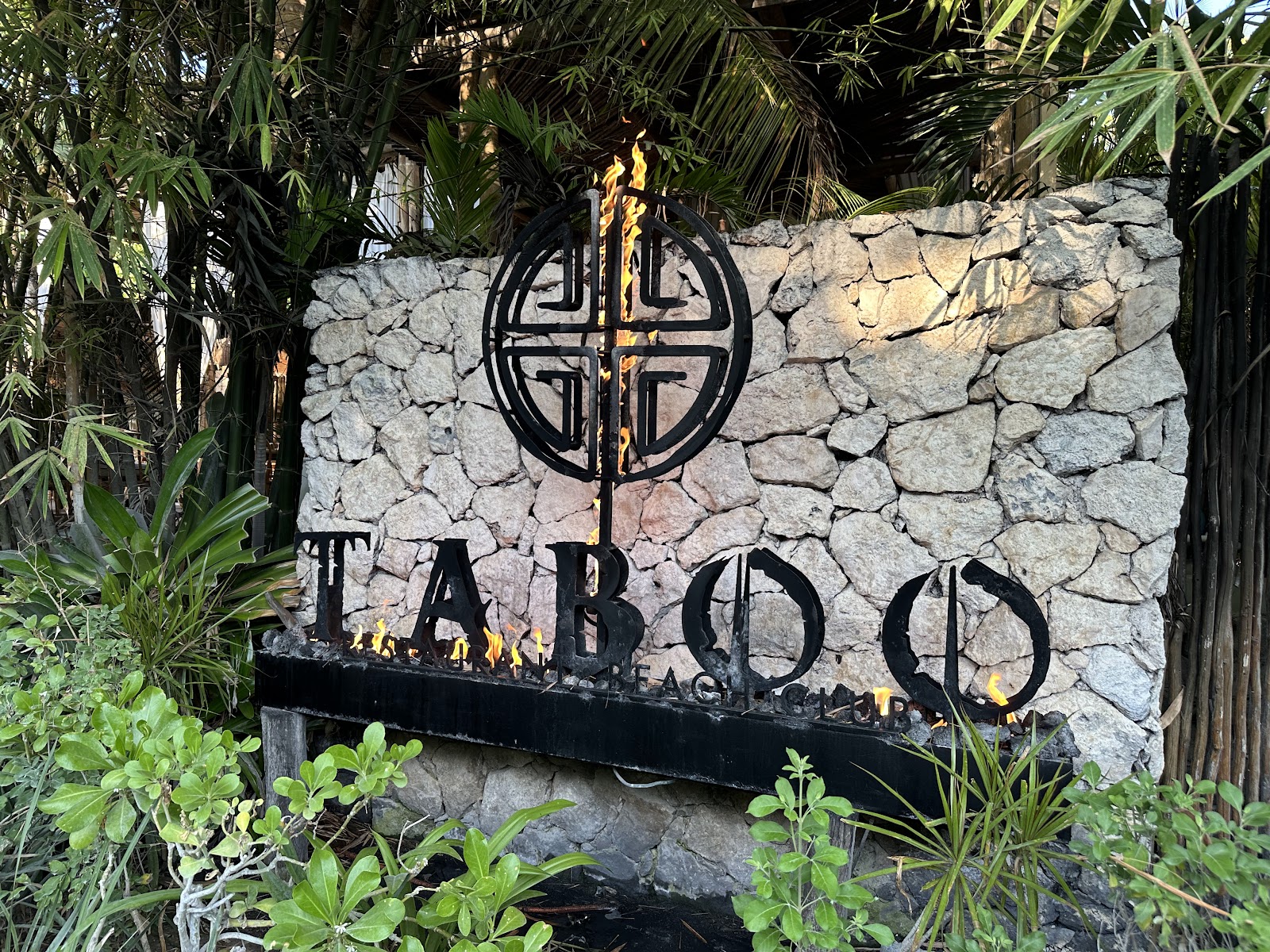 Taboo Tulum stone entrance sign surrounded by palms