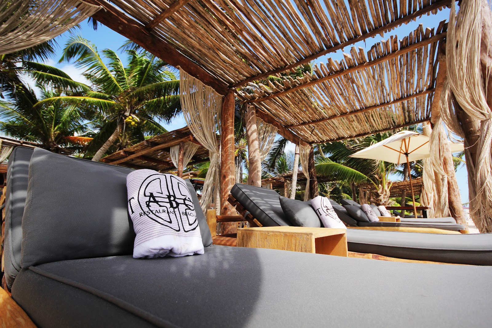 Taboo Tulum cushioned lounge bed with a branded pillow