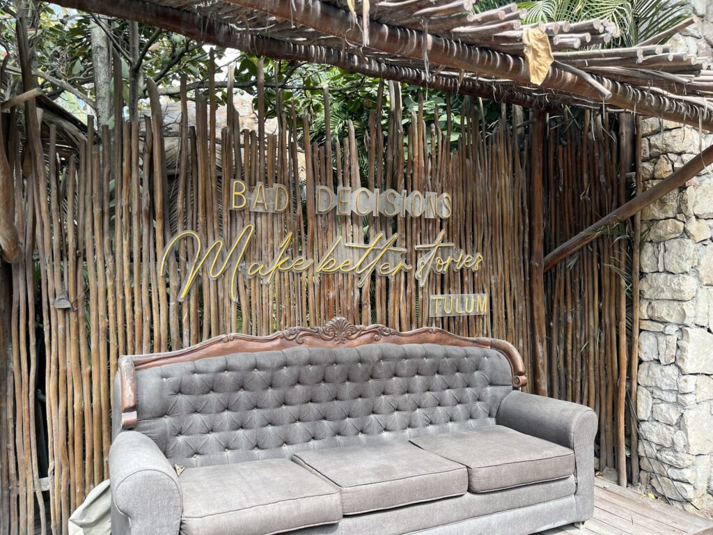 Rustic entrance lounge with a grey sofa at Tantra Beach Club Tulum