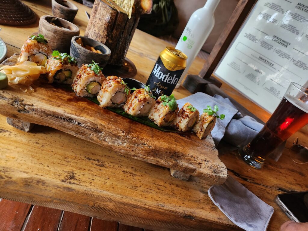 Sushi rolls on a wooden serving board at Tantra Tulum