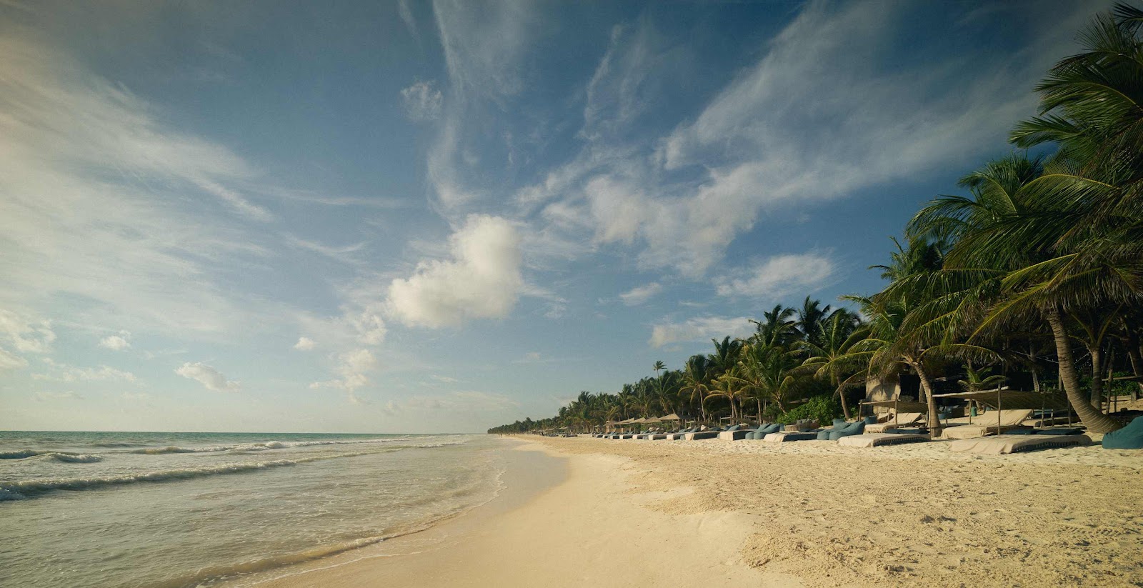 Long stretch of Tulum beach under a blue sky