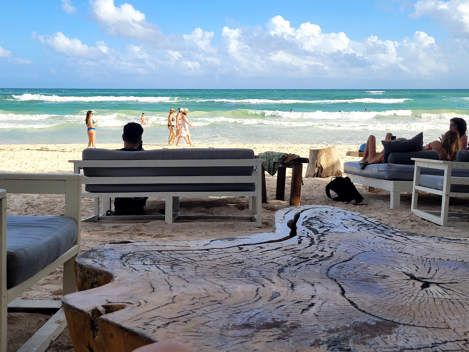 Beachfront lounge with a tree-trunk table at Tulumania