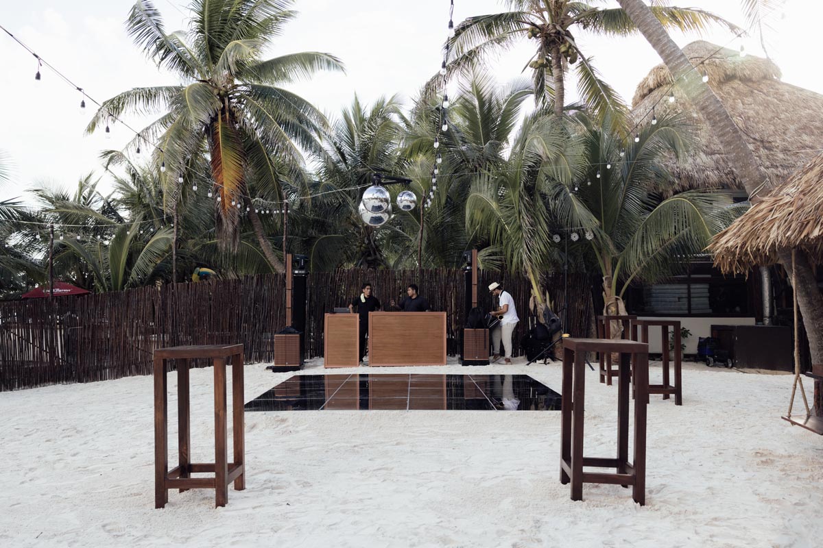 Tulumania event setup with tables among the palm trees