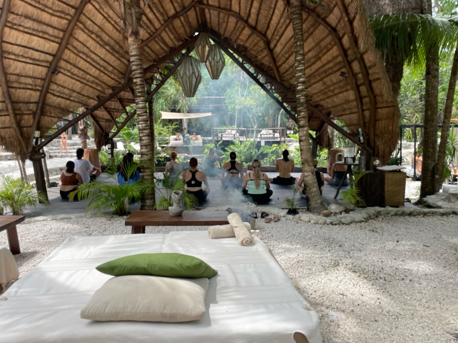 Lounge area beneath a thatched palapa at Vesica Tulum