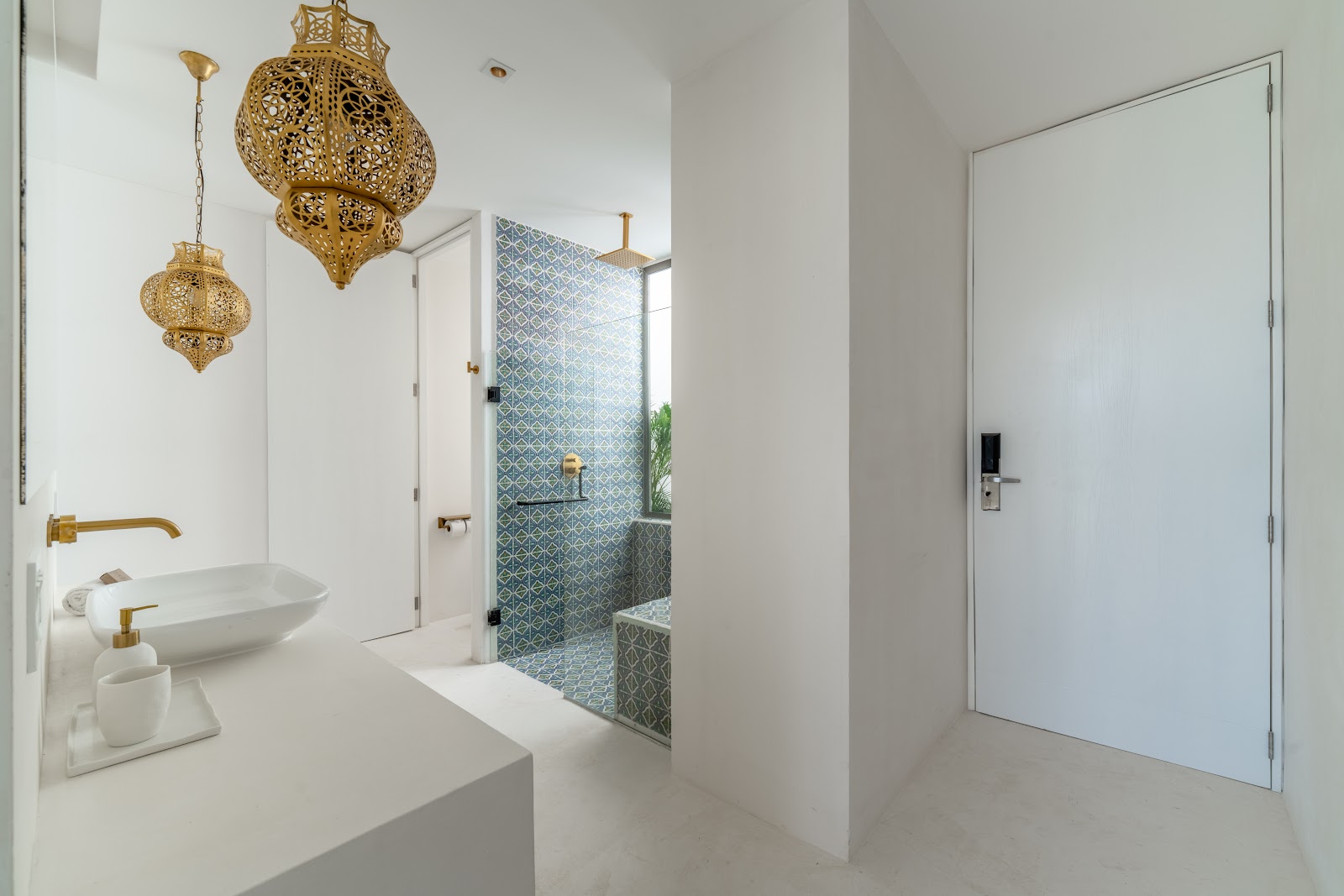 Bright white bathroom with brass fixtures and a lantern
