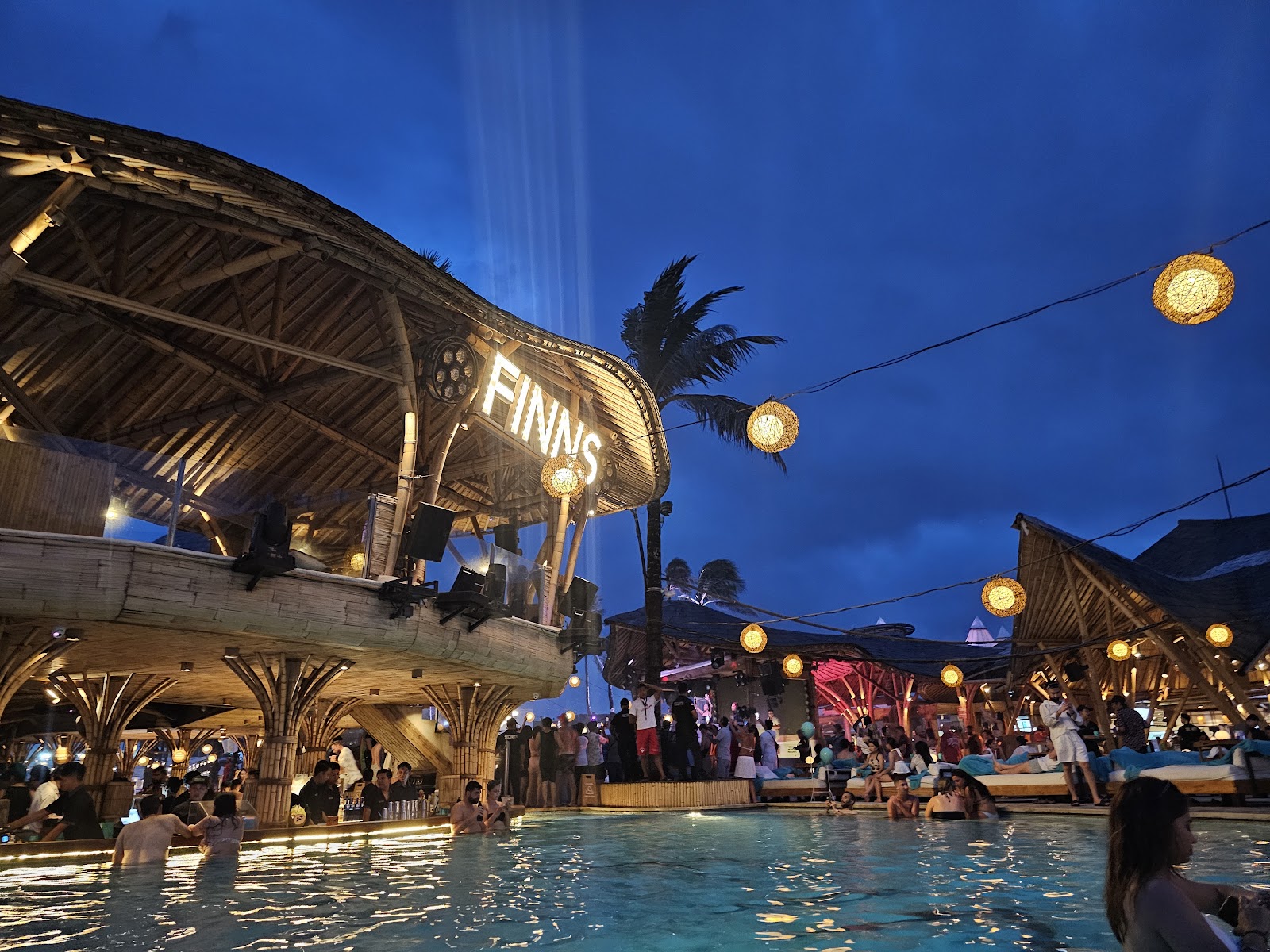 Beachfront pool lit up at night at FINNS Beach Club in Canggu
