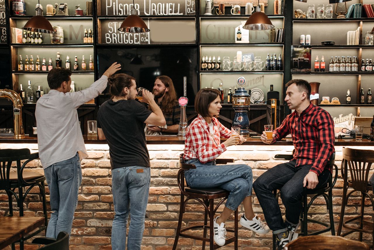 Friends enjoying drinks together at a busy cocktail bar