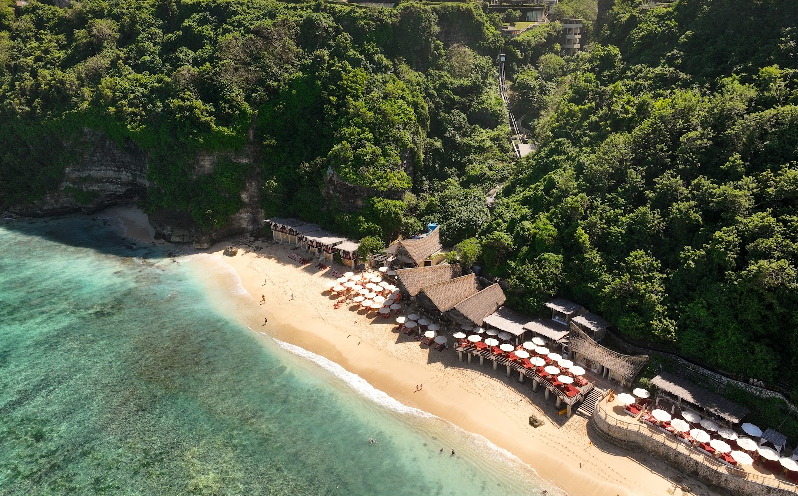Hidden white sand beach and turquoise water below the cliffs