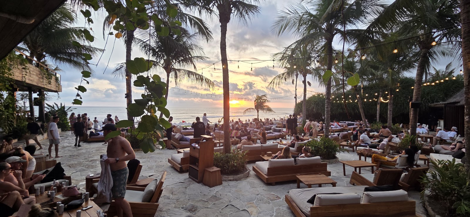 Beanbags and lounge chairs on the grass facing the sea at The Lawn Canggu